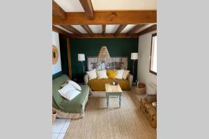 a living room with a couch and a table at Maison au coeur des Landes, Saint-Julien en Born in Saint-Julien-en-Born