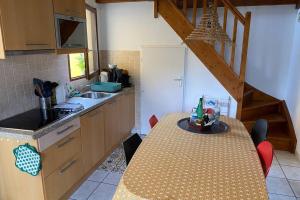 a kitchen with a table and a sink and a staircase at Maison au coeur des Landes, Saint-Julien en Born in Saint-Julien-en-Born