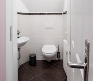 uma casa de banho branca com um WC e um lavatório em Ferienwohnung Julia em Suhl