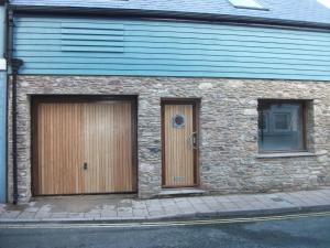 a stone building with two doors on a street at Blacksmiths in Dartmouth