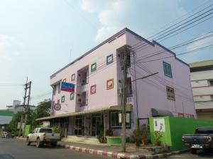um edifício cor-de-rosa ao lado de uma rua em Silver Reef em Udon Thani
