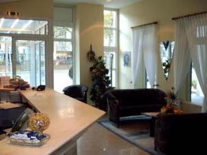 a living room with a table and chairs and windows at Hotel Antares in Oldenburg