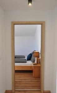 a mirror in a room with a bed and a lamp at Ferienwohnung Staudach, Apartment in Fügenberg
