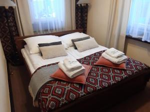 a bed with pillows and towels on top of it at Resort Kasprowy Wierch in Zakopane