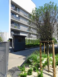 a building with a fence and a tree in front of it at Apartamenty Arkadia by VisitWarsaw Apartments in Warsaw