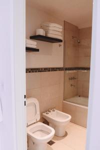 a bathroom with a toilet and a sink and a tub at Administración MAIPU 2E DEPTO PREMIUM in Tandil