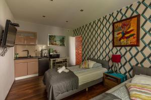 a small room with a bed and a kitchen at Villa Kava in Warsaw