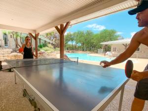 Un homme et une femme jouant au ping-pong dans l'établissement Sun Retreats San Antonio West, à San Antonio