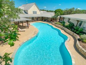 an aerial view of a swimming pool in front of a house at Sun Retreats San Antonio West in San Antonio