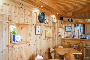 a wooden room with a table and a clock on the wall at Sylpaulerhof Aparthotel in Sankt Michael im Lungau