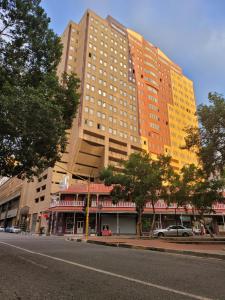 um edifício alto numa rua em frente a um edifício em The Franklin Luxury Apartments em Joanesburgo