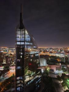 un edificio alto de cristal con una ciudad por la noche en The Franklin Luxury Apartments, Unit 1604, en Johannesburgo