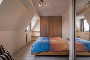 una camera con letto e lenzuola blu e arancioni di penthouse saint idesbald a Sint-Idesbald