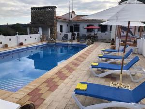 a swimming pool with chairs and an umbrella at LEMON TREE VILLA in Monserrat