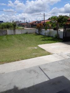 a yard with a fence and a field of grass at Jane Ilha in Ilha Comprida