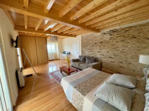 a living room with a bed and a stone wall at Casa Janeiro in Barreiros