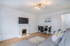 ein Wohnzimmer mit einem Sofa und einem Kamin in der Unterkunft Kentmere Apartment Thamesmead in Thamesmead
