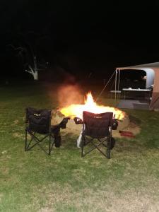 a fire pit with two chairs in front of it at Klipfontein Rustic Farm & Camping in Tulbagh