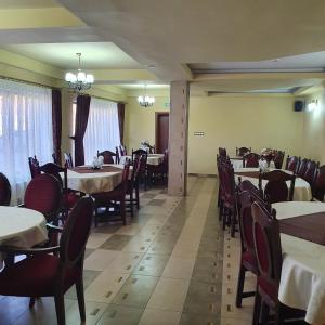 una sala da pranzo con tavoli e sedie in un ristorante di Pensiunea Mirela Peștera Urșilor a Chişcău