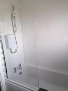 a bathroom with a shower with a bath tub at 1 Fulmar Road**Next to West Beach and Golf Course in Lossiemouth