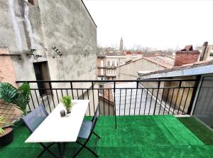 een balkon met een witte tafel en stoelen in een gebouw bij LA TERRASSE DE JEANNE - Vue Magnifique - Netflix in Toulouse