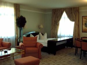 un soggiorno con letto, divano e sedie di Hotel Alexander a Oldenburg