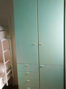 a green cabinet with white handles next to a bed at ALLOGGIO S.ANNA in Isola del Giglio