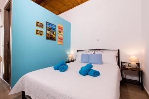 a bedroom with a white bed with blue pillows on it at M & E Kissamos sea view house in Kissamos