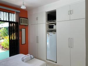 a kitchen with white cabinets and a refrigerator at Amanda Suites in Manaus