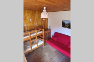 a living room with a red couch and a table at Le chalet de Flo in Séez