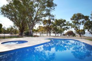 a swimming pool with blue water in a park at Discovery Parks - Lake Bonney in Barmera