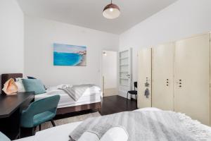 a bedroom with two beds and a desk and a bed at Apartman Altamar Rijeka in Rijeka