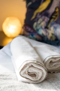 a roll of white towels sitting on a bed at Apartman Altamar Rijeka in Rijeka +60 photos