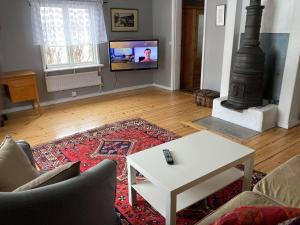 a living room with a white coffee table and a fireplace at Setons Stuga in Lindesberg