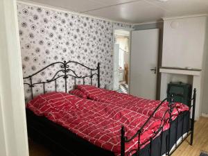 a bedroom with a bed with a red comforter at Setons Stuga in Lindesberg