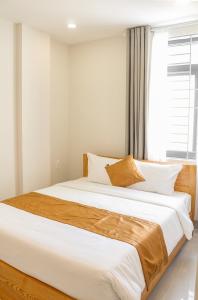 a large bed in a bedroom with a window at Anh Đào Hotel in Vung Tau