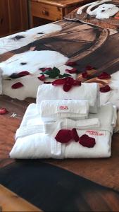 eine Gruppe weißer Handtücher mit roten Blumen darauf in der Unterkunft Paradiso della Bici in Morbegno