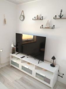 a white dresser with a television on top of it at Ferienwohnung Braun 'Haus Fidi' in Borkum