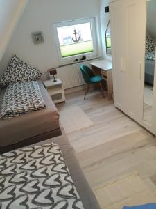 a bedroom with a bed and a desk and a window at Ferienwohnung Braun 'Haus Fidi' in Borkum