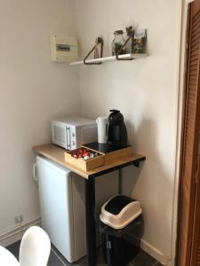 a small table with a coffee maker and a microwave at L’été de Mélusine in Niort