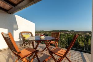patio con mesa y sillas en el balcón en Apartments Villa Verde-Adults Only, en Mušalež