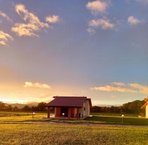 a small house with a red roof on a field at Agriturismo Oasi del Pianettino in Campagnatico