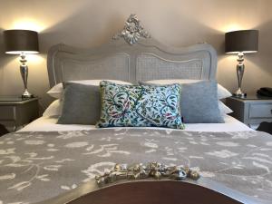 a bedroom with a large bed with two lamps at Combe House Hotel in Holford +13 photos