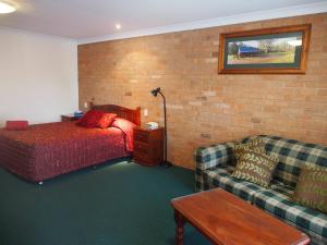 a hotel room with a bed and a couch at Cobar Town & Country Motor Inn in Cobar