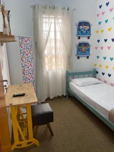 - une chambre avec un lit, un bureau et une fenêtre dans l'établissement Pousada Santa Lolla, à São Carlos