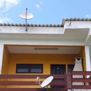 a house with a surfboard on the front of it at Apartamento Morada do Sol in Ilha Comprida