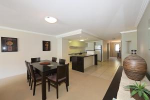 a dining room and kitchen with a table and chairs at Pacific Reef by Kacys in Bargara