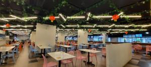 a dining room with tables and chairs and lights at Arena SOHO at Kozi Square Kuching in Kuching