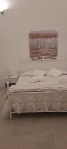 a white bedroom with a bed and a desk at Casa Vacanze Laura1 in Lecce