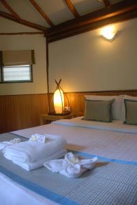 two beds in a room with towels on them at Montalay - Eco Cottage Koh Tao in Ko Tao